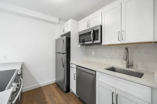 a kitchen with stainless steel appliances a sink and a refrigerator