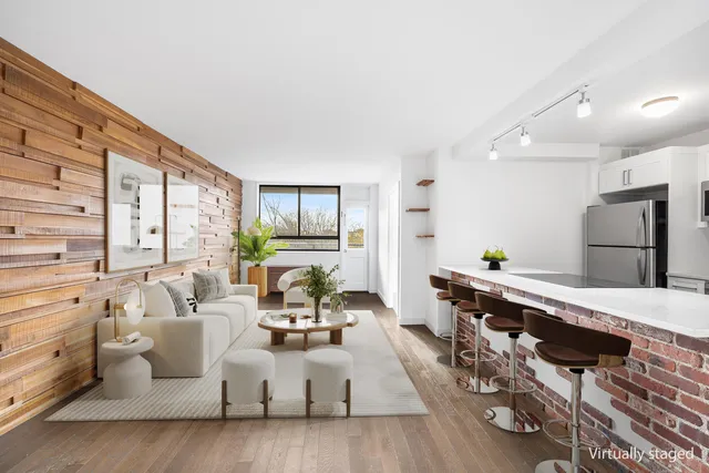 a living room with furniture fireplace and a large window