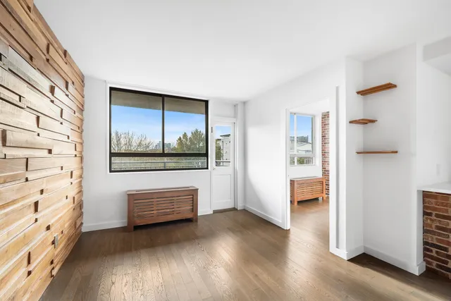 a view of front door with hallway and wooden floor