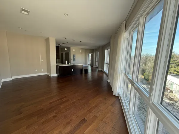 a view of a hallway with wooden floor and furniture