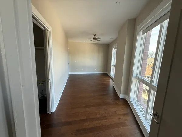 a view of a hallway with wooden floor and staircase