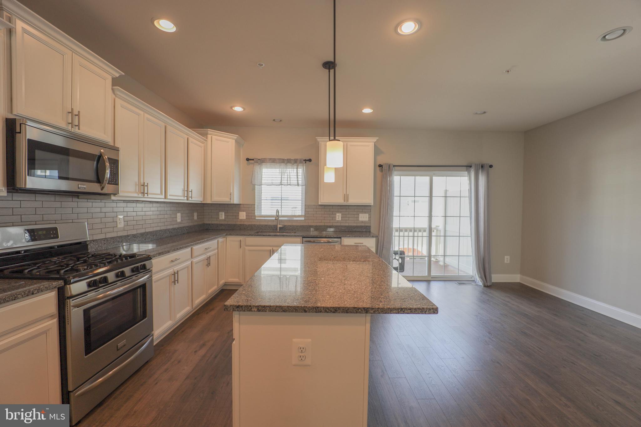 5054 Judicial Way Frederick, MD 21703 - Photo 11 of 28 a kitchen with granite countertop wooden floors appliances and cabinets