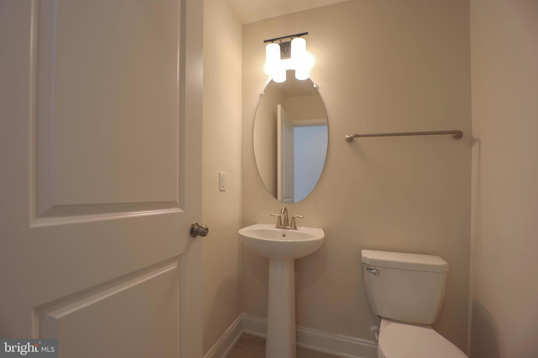 5054 Judicial Way Frederick, MD 21703 - Photo 3 of 28 a bathroom with a toilet a sink and mirror
