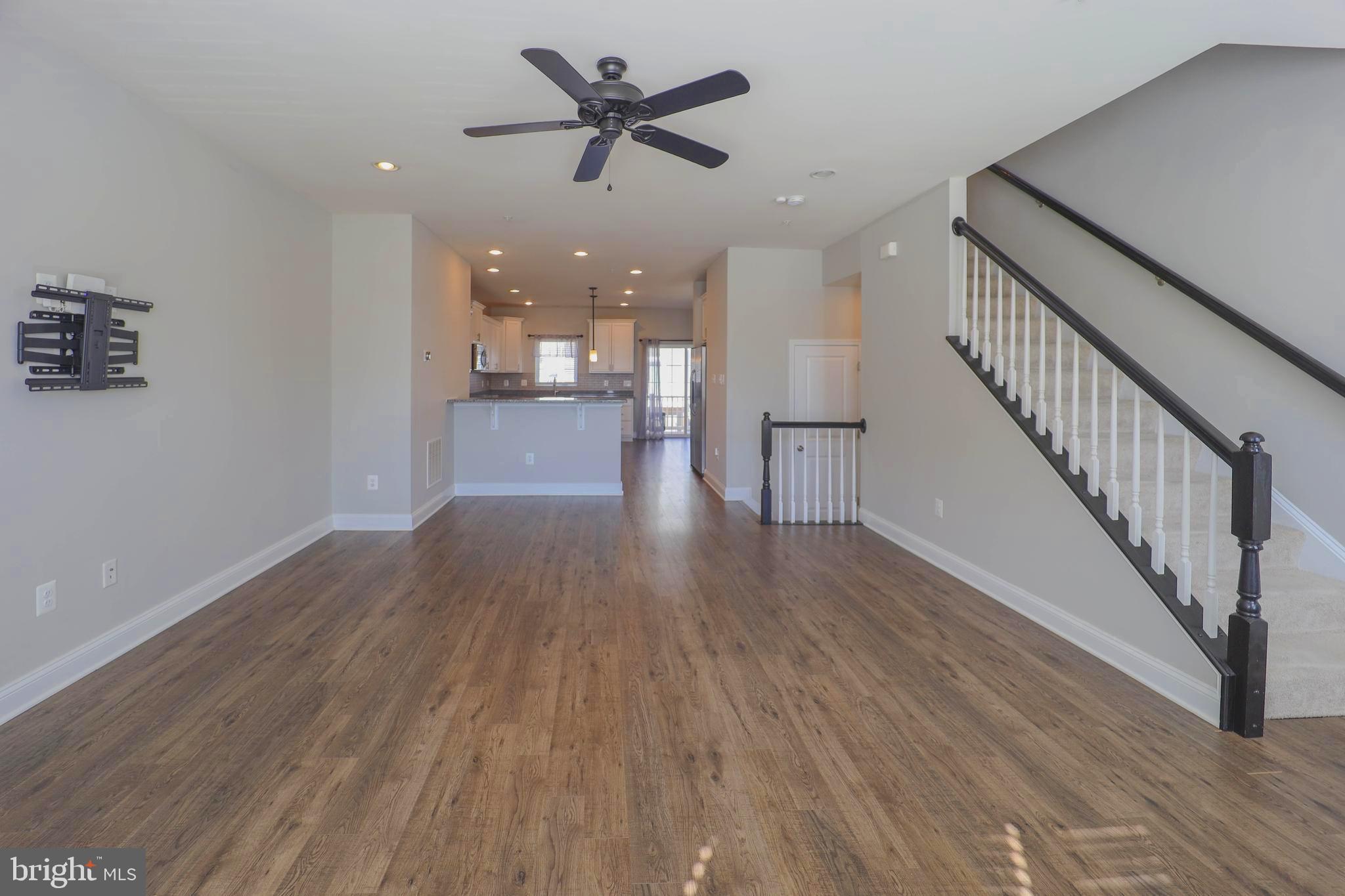 5054 Judicial Way Frederick, MD 21703 - Photo 6 of 28 a view of a hallway with wooden floor and a ceiling fan