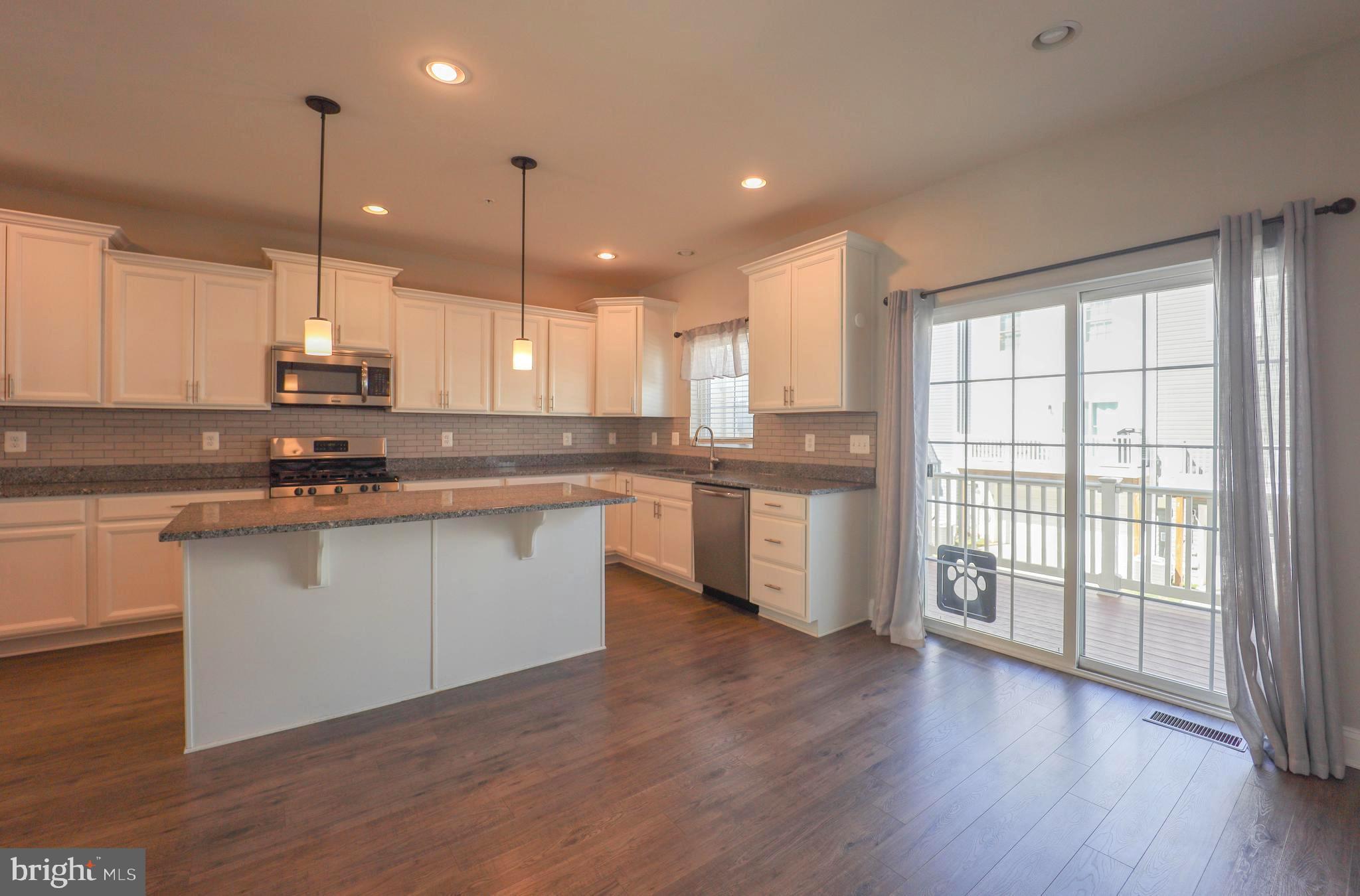 5054 Judicial Way Frederick, MD 21703 - Photo 8 of 28 a kitchen with stainless steel appliances granite countertop wooden floors cabinets and a sink