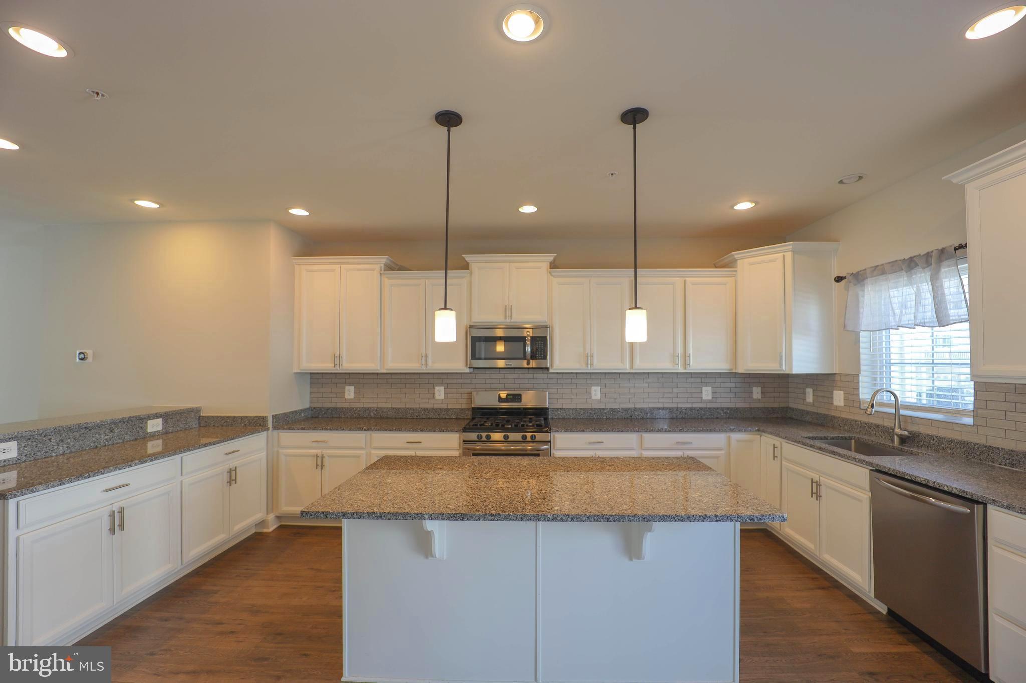 5054 Judicial Way Frederick, MD 21703 - Photo 9 of 28 a kitchen with stainless steel appliances granite countertop a sink a stove a kitchen island and cabinets