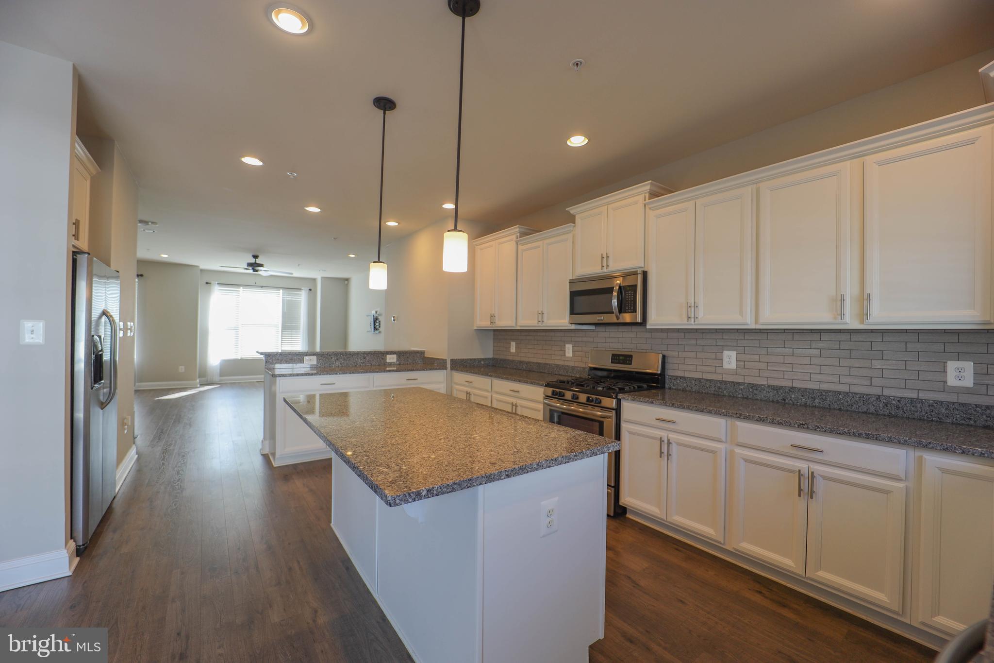 5054 Judicial Way Frederick, MD 21703 - Photo 10 of 28 a kitchen with stainless steel appliances granite countertop a sink a stove and a wooden floors