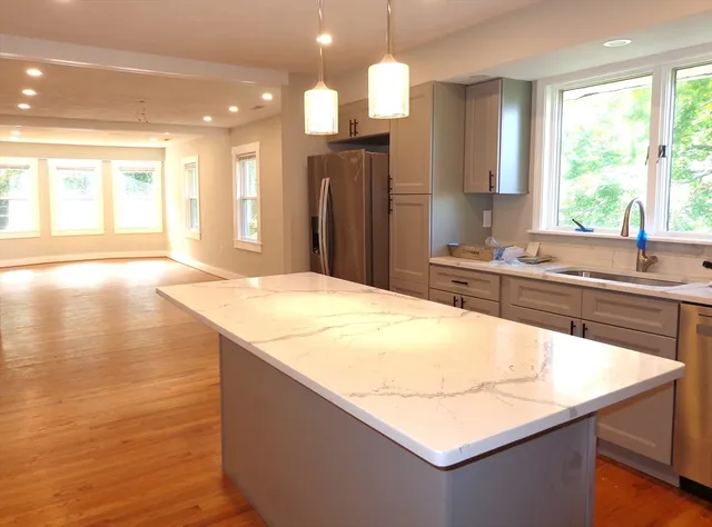 a kitchen with stainless steel appliances granite countertop a sink a stove and a refrigerator