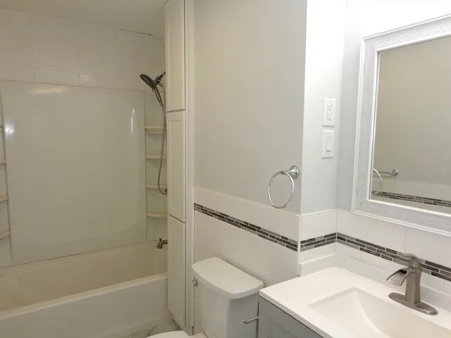 a bathroom with a sink mirror toilet and bathtub