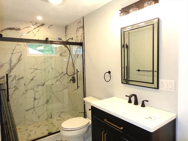a bathroom with a sink mirror toilet and shower