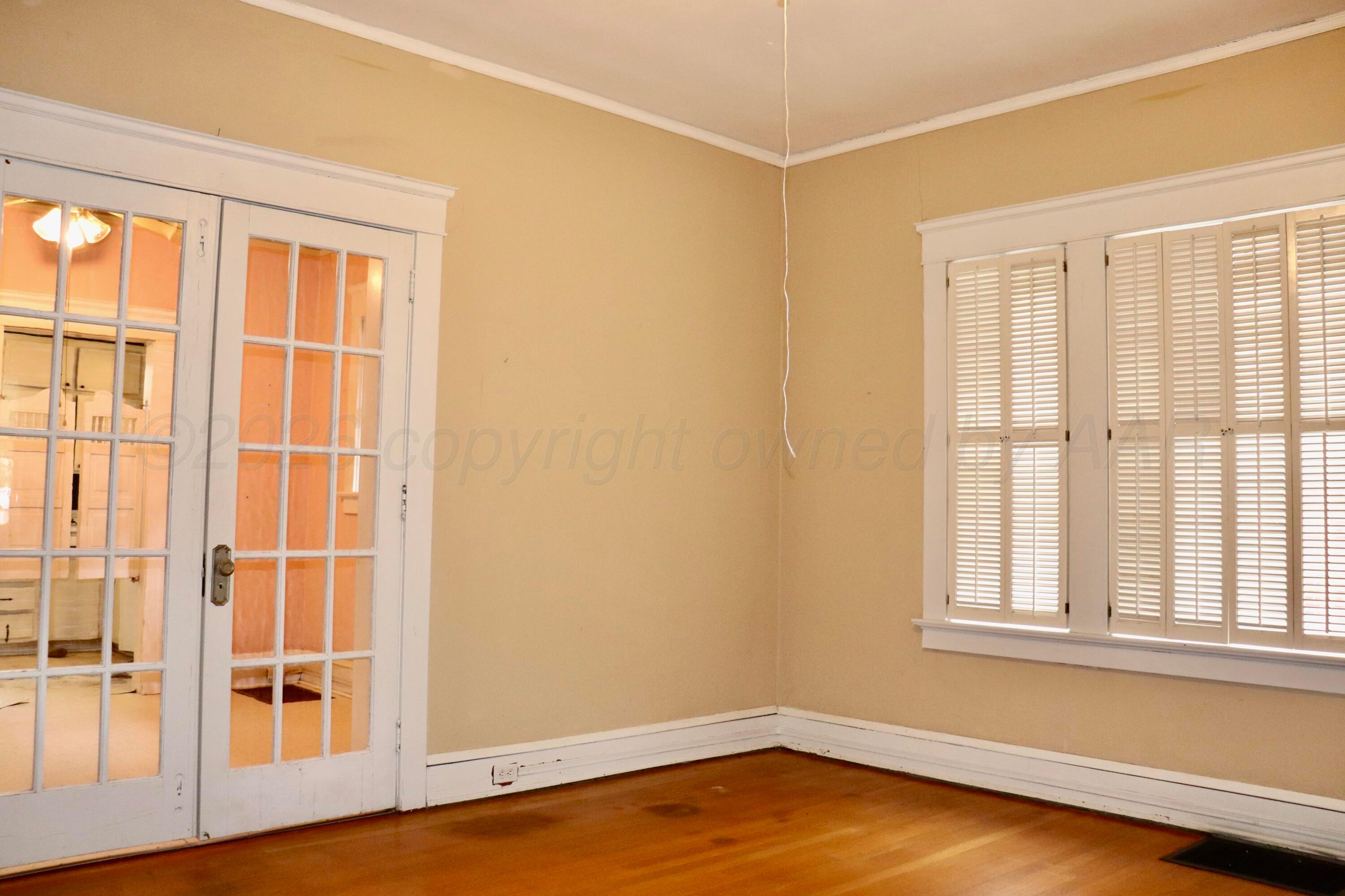 1912 South Tyler Street Amarillo, TX 79109 - Photo 14 of 74 an empty room with wooden floor and windows with curtains