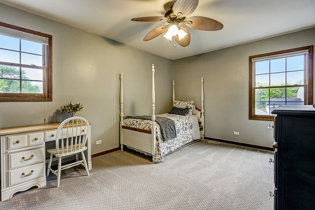 2767 Sun Valley Road Lisle, IL 60532 - Photo 13 of 23 a spacious bedroom with a bed next to a window and a chandelier