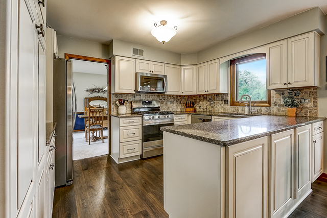 2767 Sun Valley Road Lisle, IL 60532 - Photo 5 of 23 a kitchen with kitchen island granite countertop a stove top oven a sink a counter space and cabinets