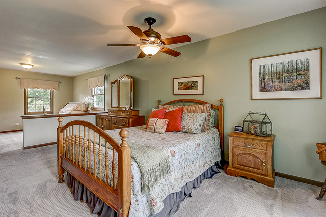 2767 Sun Valley Road Lisle, IL 60532 - Photo 10 of 23 a bedroom with a bed a chandelier and dresser