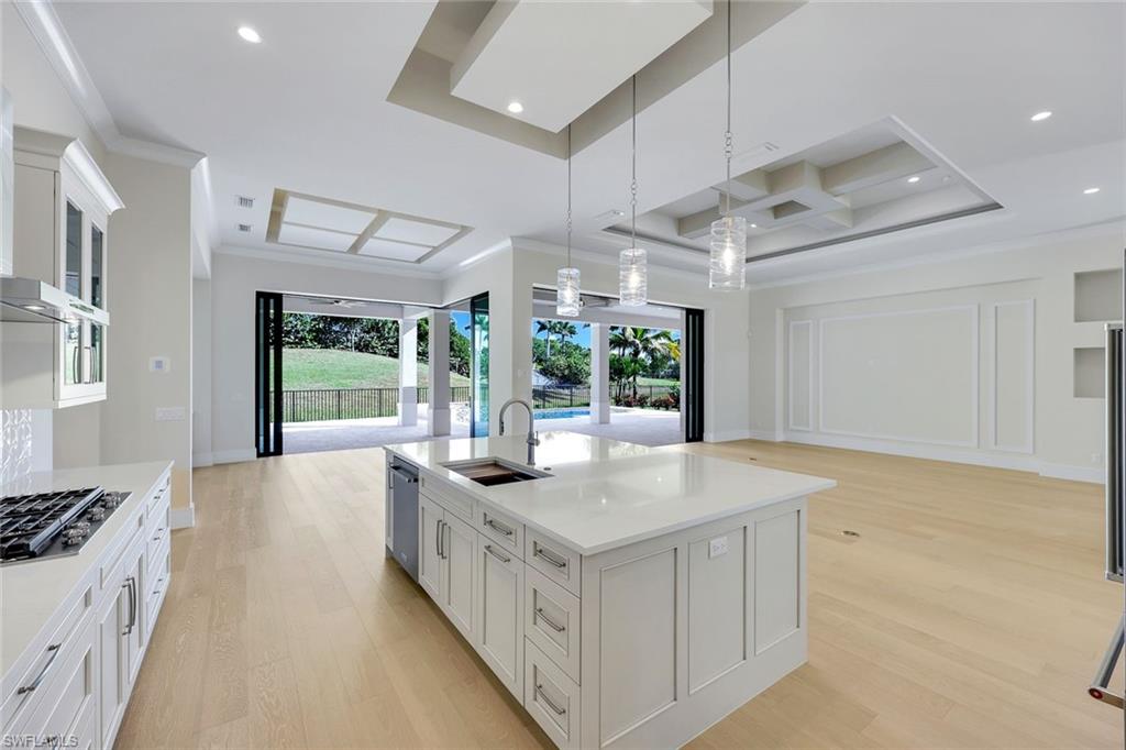 14282 Charthouse Circle Naples, FL 34114 - Photo 47 of 48 Kitchen with open floor plan, white cabinets, light wood-type flooring, coffered ceiling, and ornamental molding