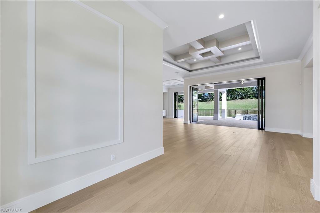 14282 Charthouse Circle Naples, FL 34114 - Photo 10 of 48 Unfurnished room featuring coffered ceiling, light wood-style floors, beam ceiling, crown molding, and recessed lighting