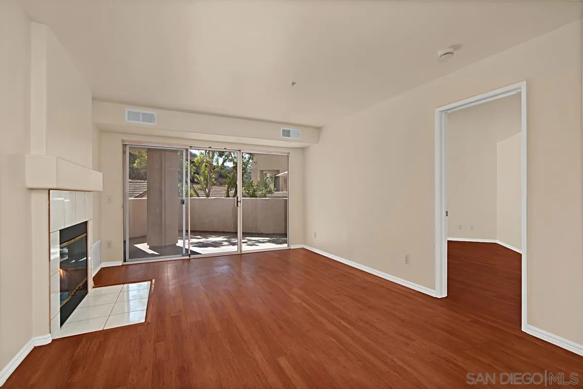 11235 Affinity Court, Unit 68 San Diego, CA 92131 - Photo 5 of 29 a view of an empty room with wooden floor and a window