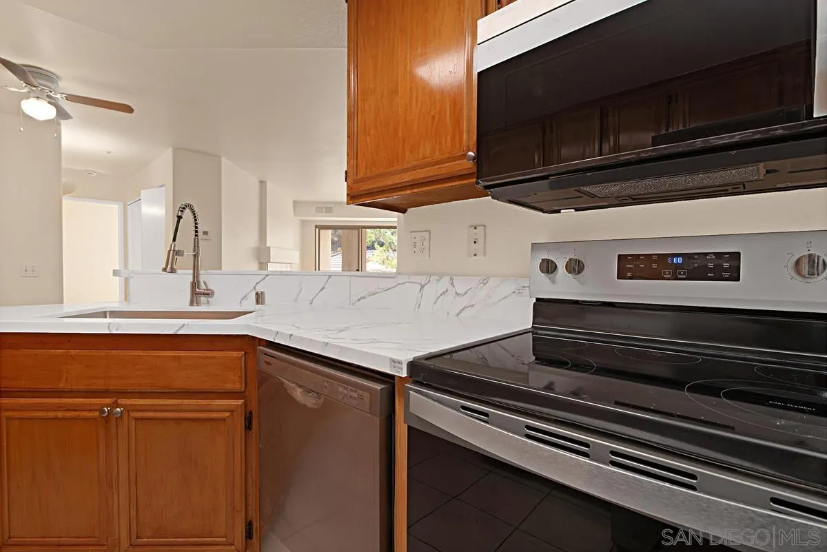 11235 Affinity Court, Unit 68 San Diego, CA 92131 - Photo 10 of 29 a kitchen with wooden cabinets and a stove top oven
