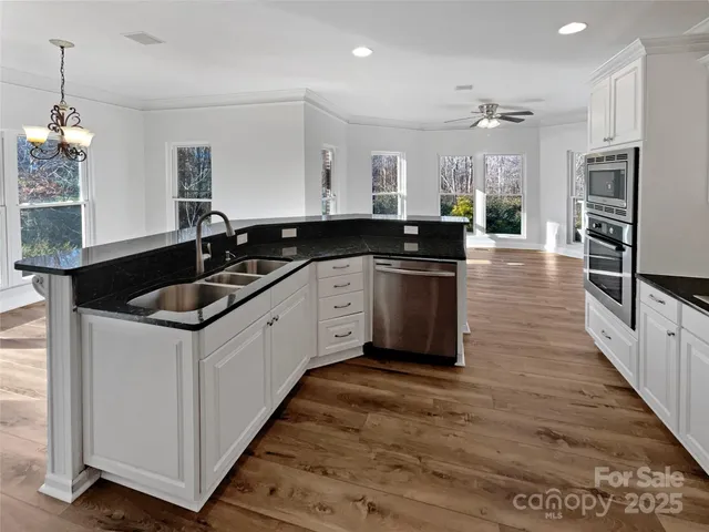 a kitchen with stainless steel appliances granite countertop a sink and a refrigerator