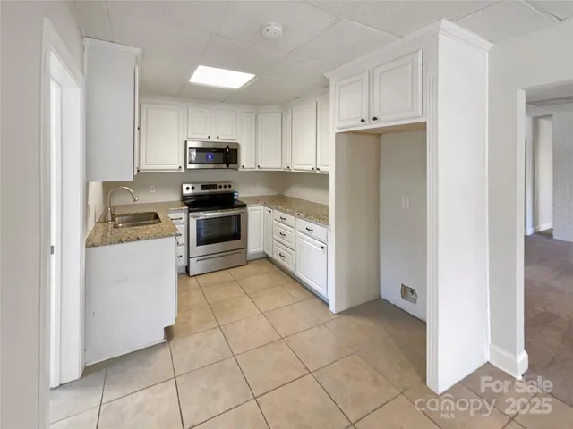 a kitchen with white cabinets and stainless steel appliances