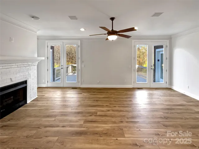 a view of empty room with wooden floor and fireplace