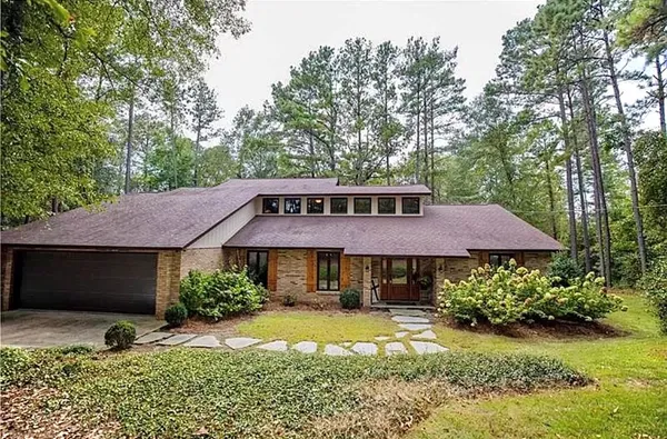 a front view of a house with yard and green space
