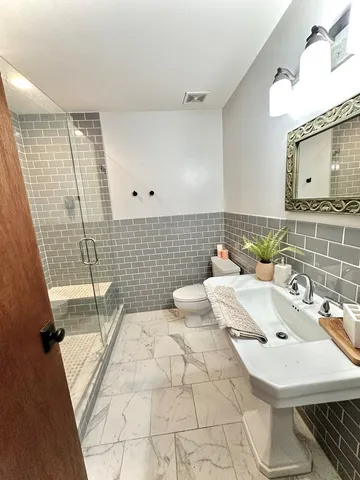a bathroom with a sink a toilet and mirror