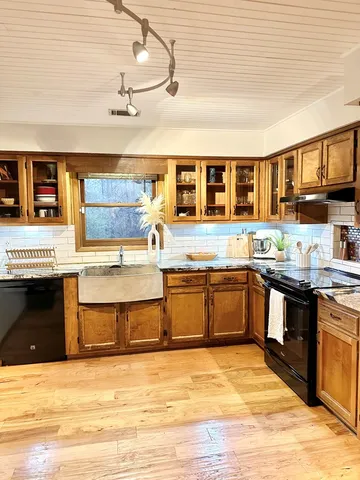 a large kitchen with stainless steel appliances granite countertop a stove and a sink