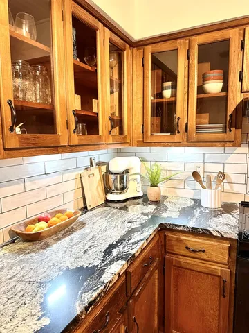 a kitchen with granite countertop sink and cabinets
