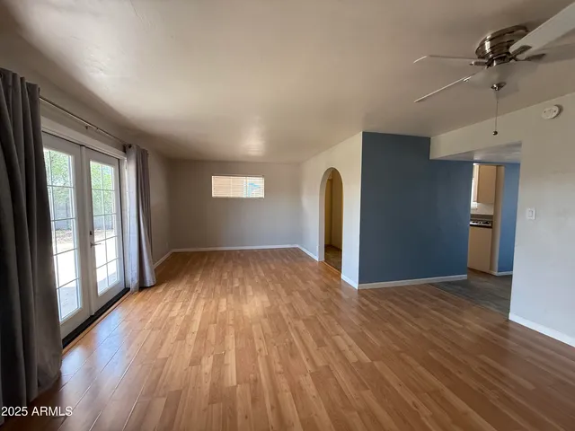 a view of empty room with window and wooden floor