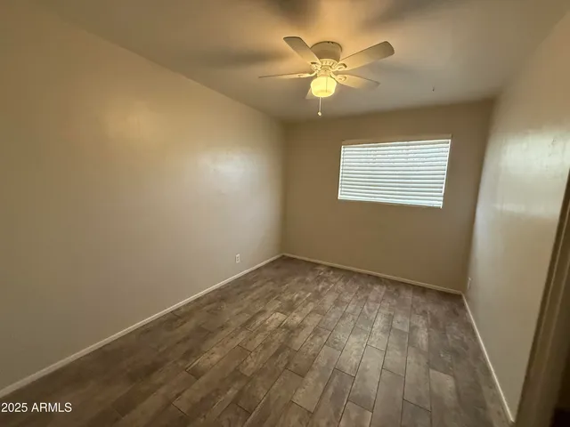 an empty room with a window and wooden floor