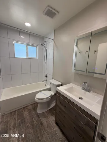 a bathroom with a sink a toilet a mirror and bathtub