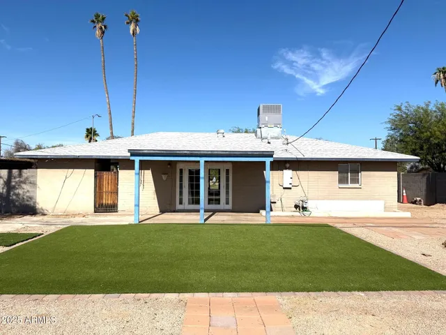 a view of a house with a yard and sitting area