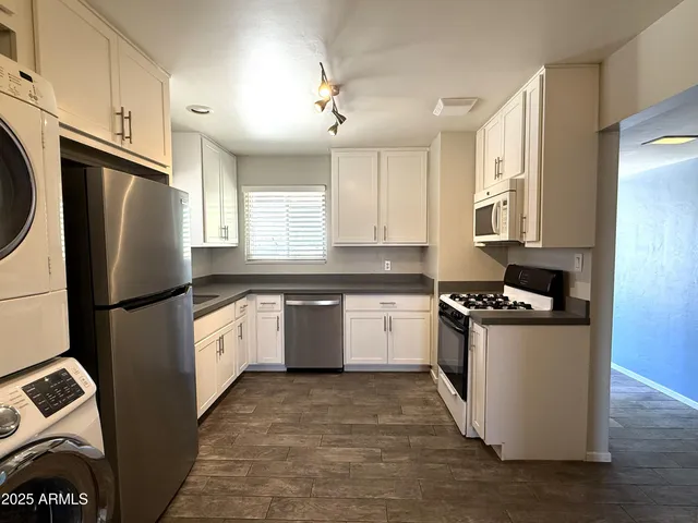 a kitchen with granite countertop a refrigerator and a sink