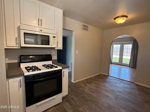 a kitchen with stainless steel appliances granite countertop a stove and a microwave