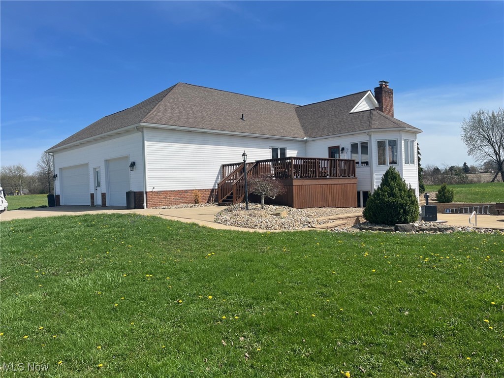 2159 Alliance Road Deerfield, OH 44411 - Photo 4 of 33 Rear view of house featuring a yard, an attached garage, a chimney, and a deck