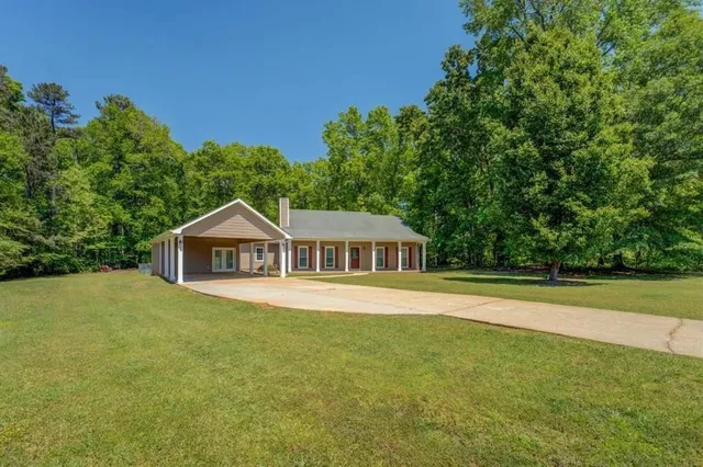a front view of a house with a yard and trees
