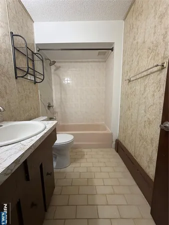 a bathroom with a granite countertop sink a toilet and shower