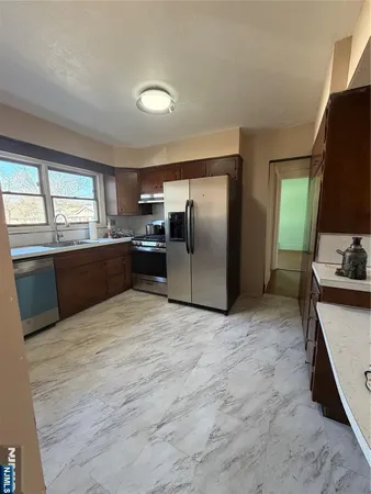a kitchen with stainless steel appliances granite countertop a refrigerator sink and stove