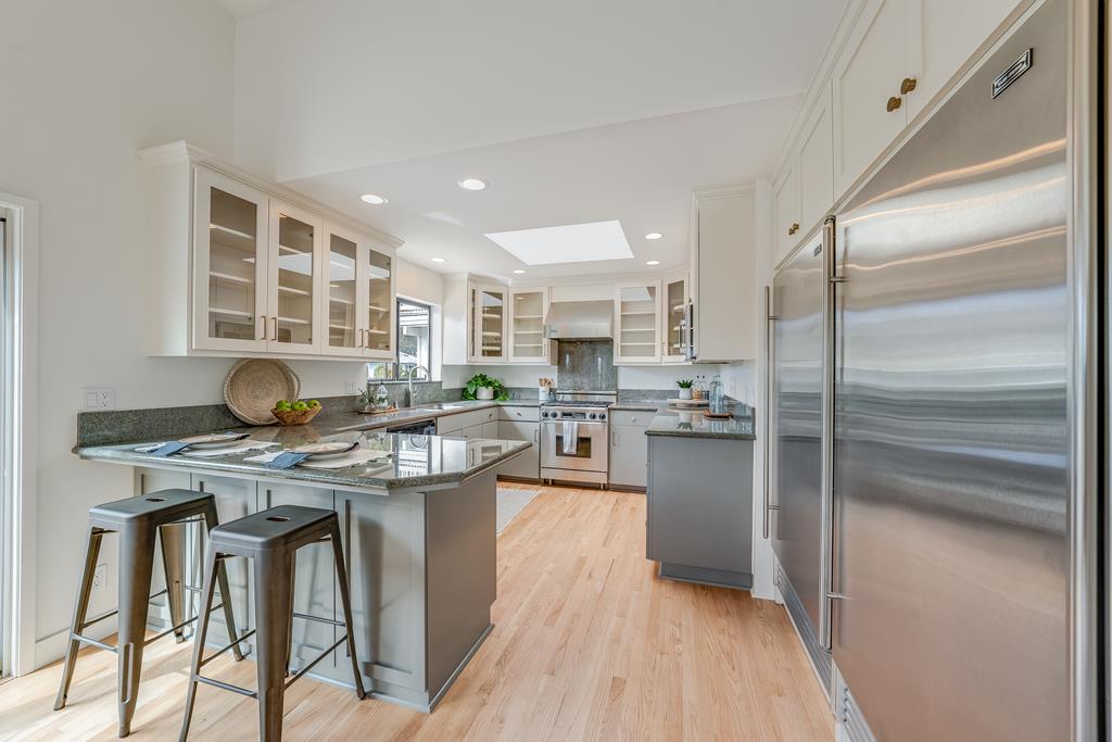 117 El Camino Del Mar Aptos, CA 95003 - Photo 4 of 60 a kitchen with a table chairs refrigerator and cabinets