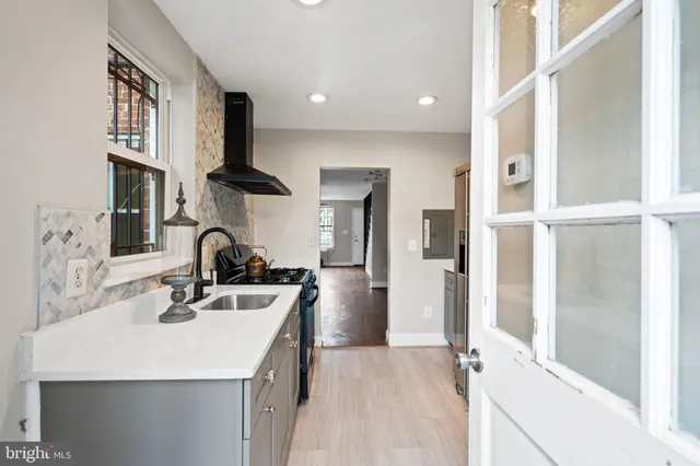 a kitchen with a sink a refrigerator and cabinets