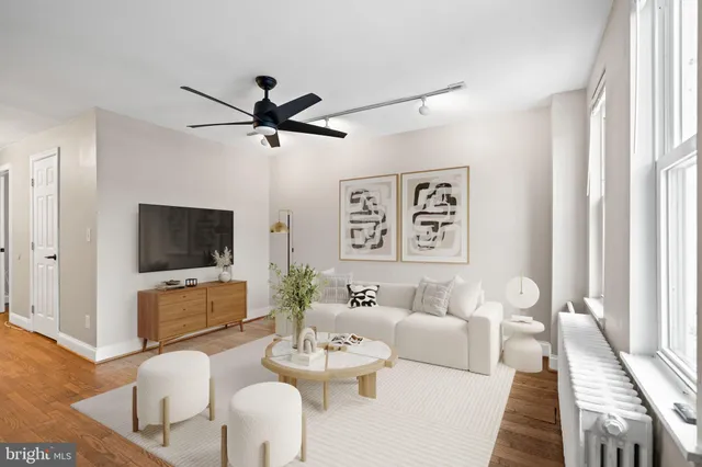 a living room with furniture a flat screen tv and a window