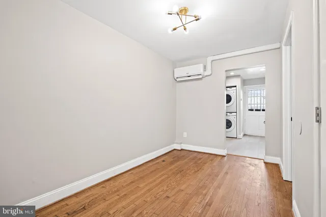 a view of empty room with wooden floor and ceiling fan