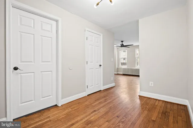 an empty room with wooden floor and closet area