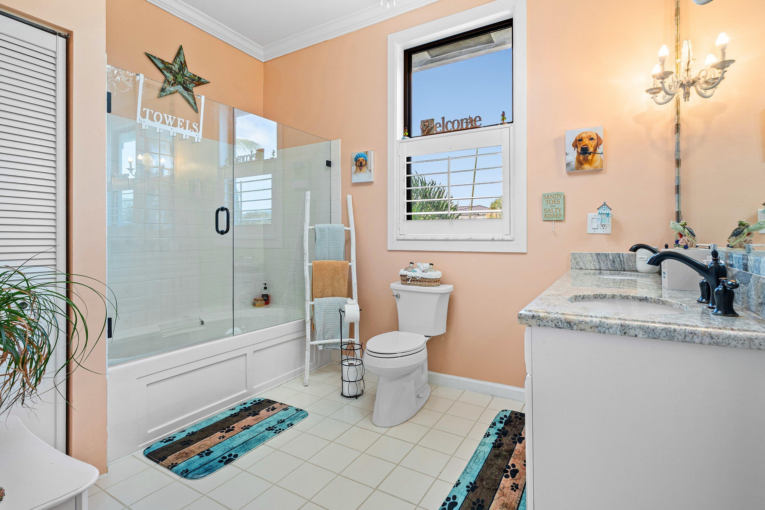 19 East Ocean Avenue Ocean Ridge, FL 33435 - Photo 14 of 24 a bathroom with a granite countertop sink a toilet a mirror and shower