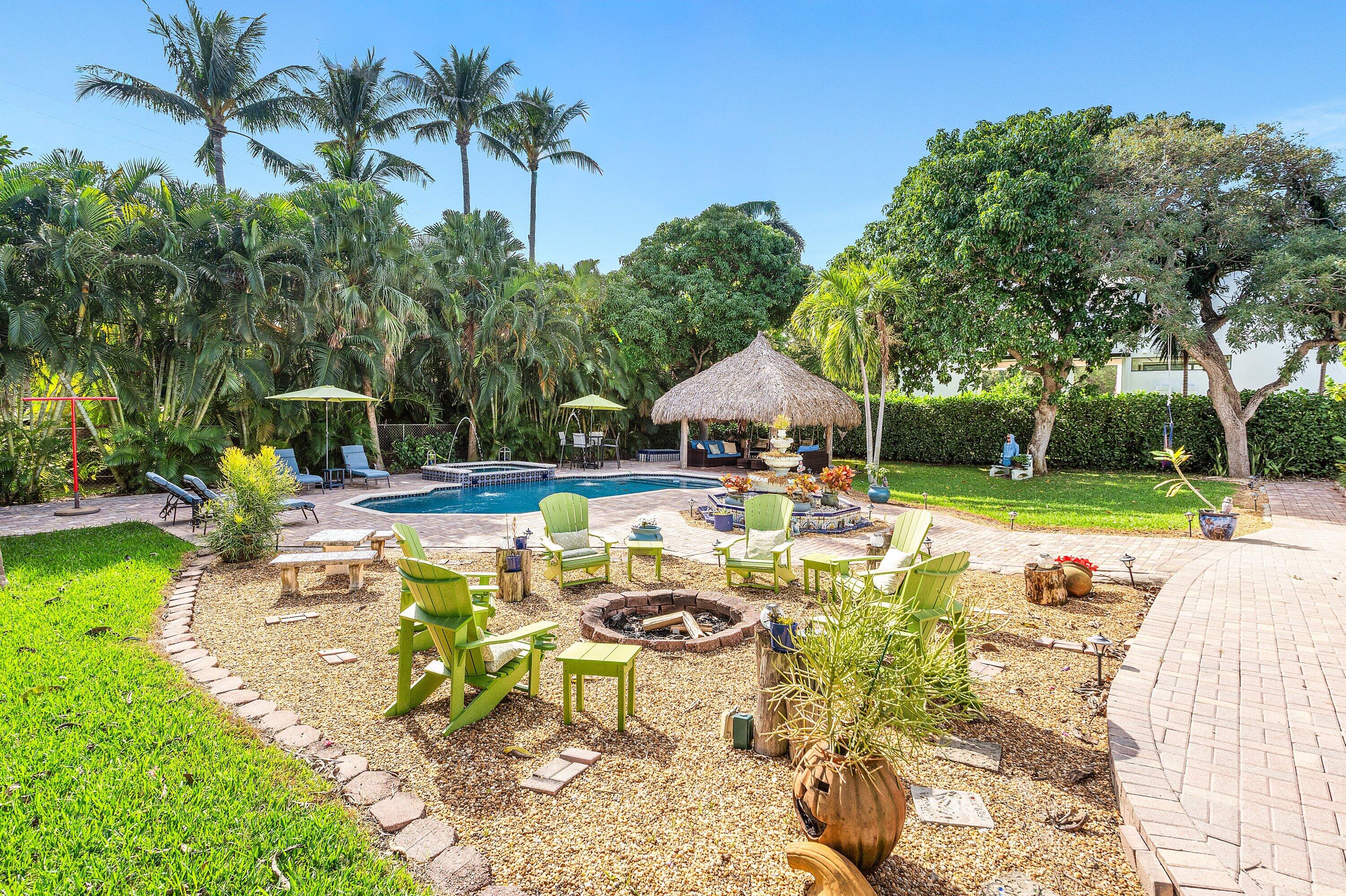 19 East Ocean Avenue Ocean Ridge, FL 33435 - Photo 20 of 24 a view of swimming pool with lawn chairs plants and large trees