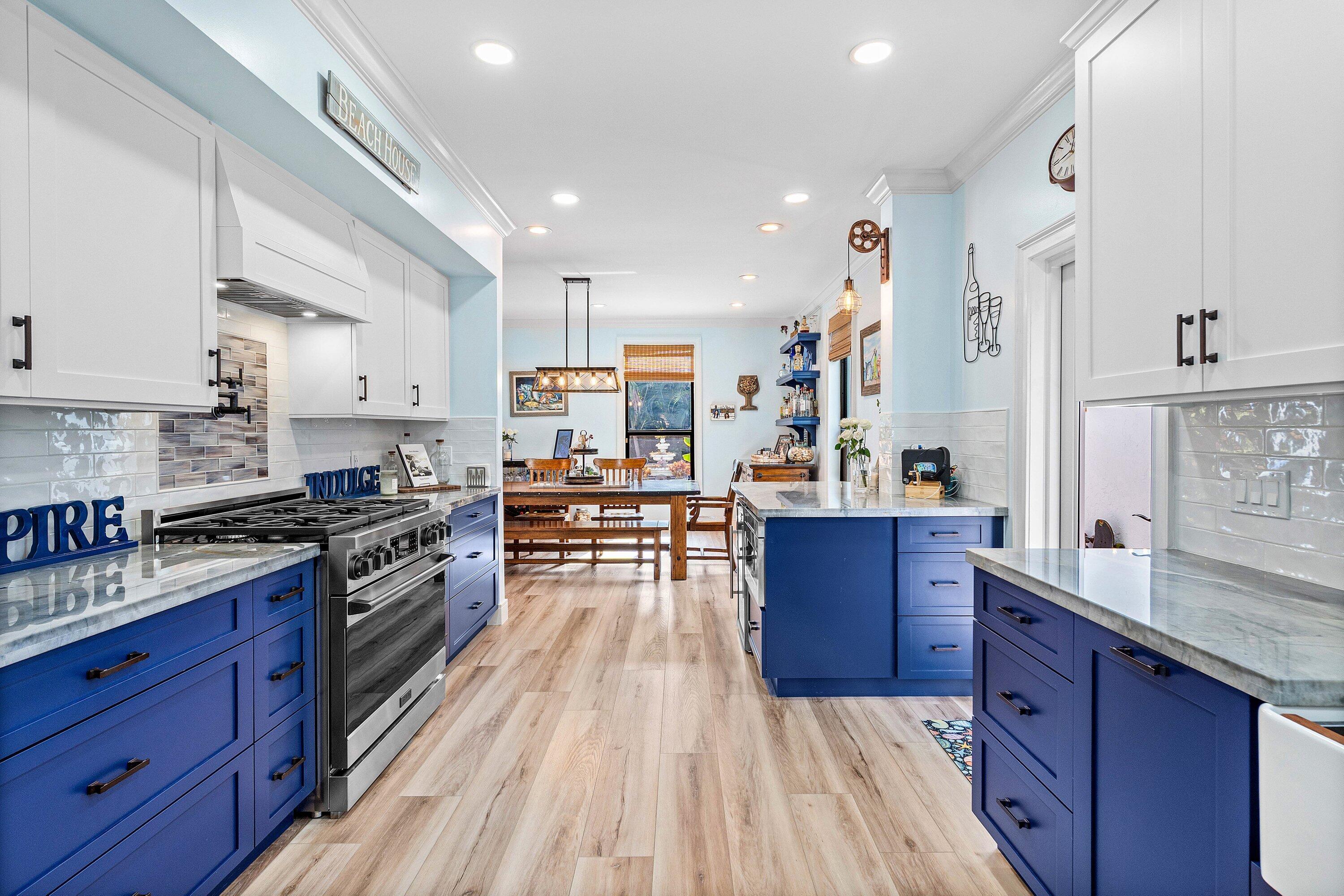 19 East Ocean Avenue Ocean Ridge, FL 33435 - Photo 9 of 24 a large kitchen with stainless steel appliances wooden floors and wooden cabinets