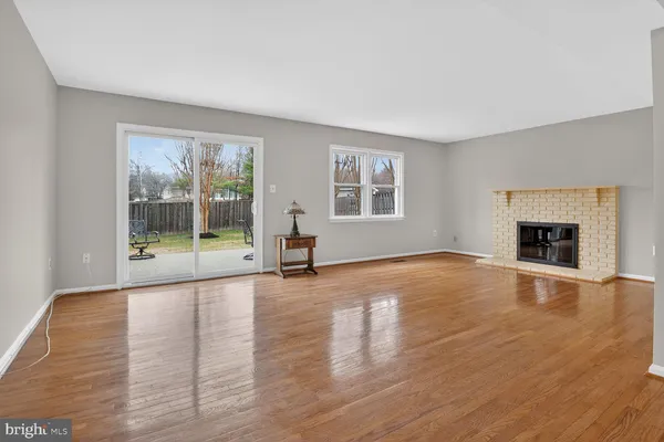 a view of empty room with wooden floor and fireplace