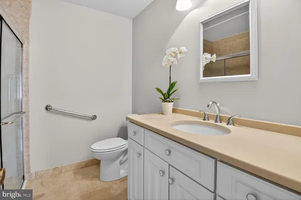 a bathroom with a granite countertop sink a toilet and a mirror