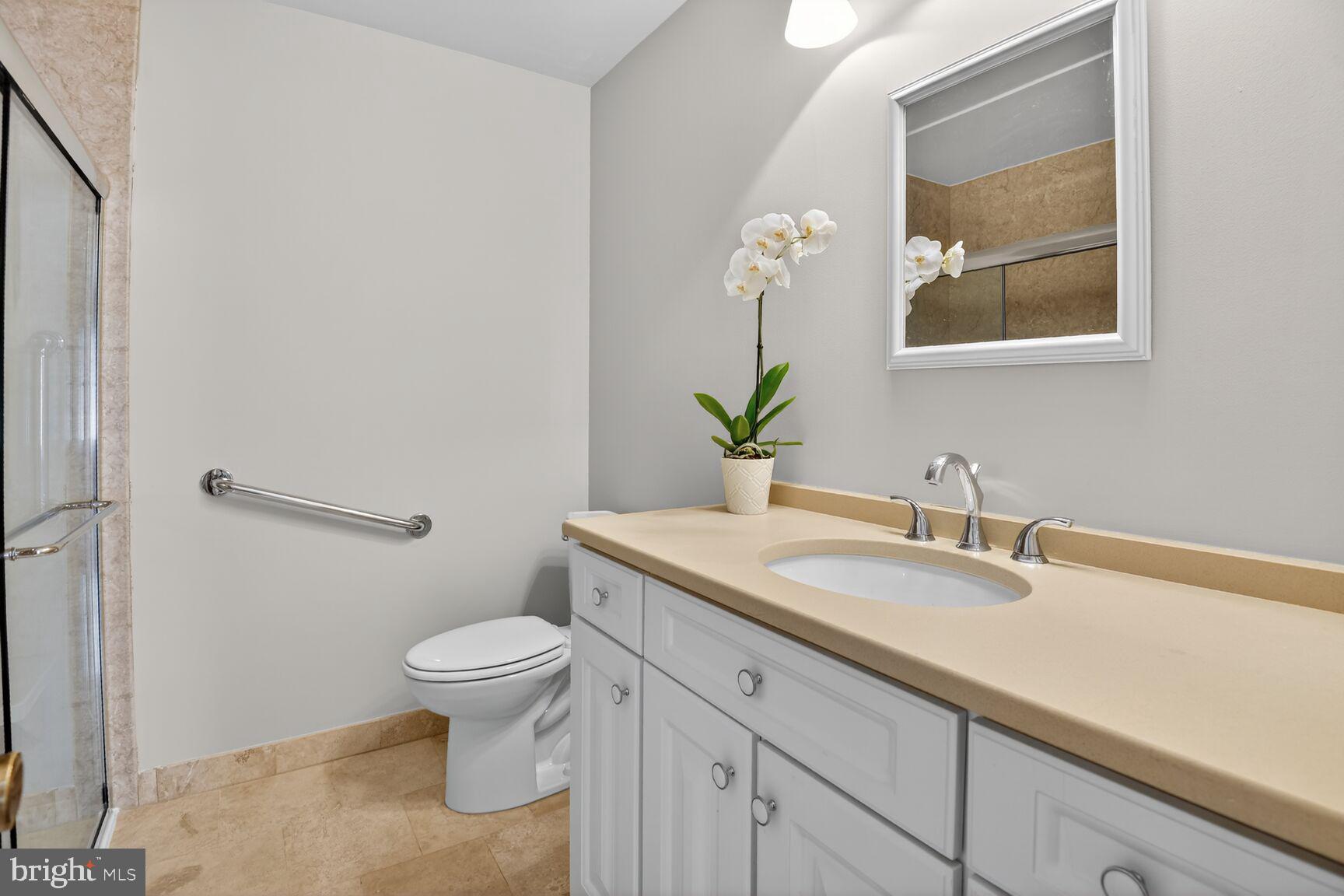 7140 Hamor Lane Springfield, VA 22153 - Photo 22 of 29 a bathroom with a granite countertop sink a toilet and a mirror